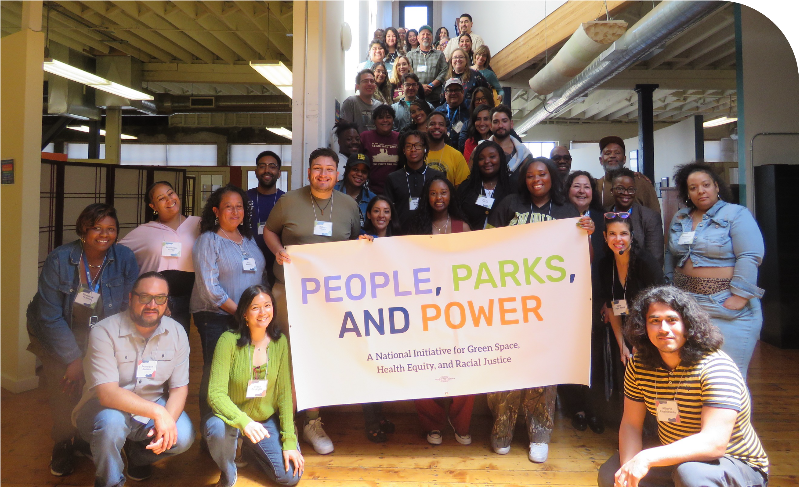 Group photo of approximately 40 People, Parks, and Power (P3) partners standing on a staircase and in front of a banner that reads “People, Parks, and Power: A National Initiative for Green Space, Health Equity, and Racial Justice.” The group is smiling and gathered in a bright, open indoor space during the 2025 annual convening in Oakland, California.