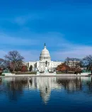 the U.S. Capitol reflected in a pool, symbolizing federal policymaking and national governance