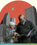 two older adults stand together, examining a document