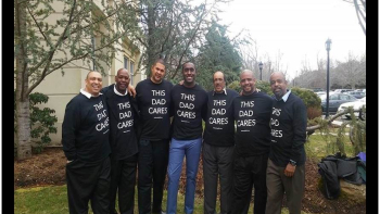 a group of men wearing "This Dad Cares" shirts